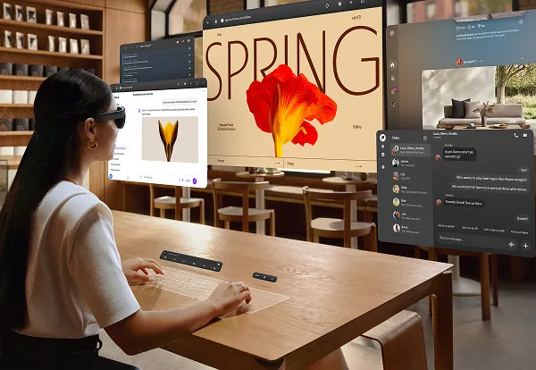 Multiple large virtual screens floating above a real desk