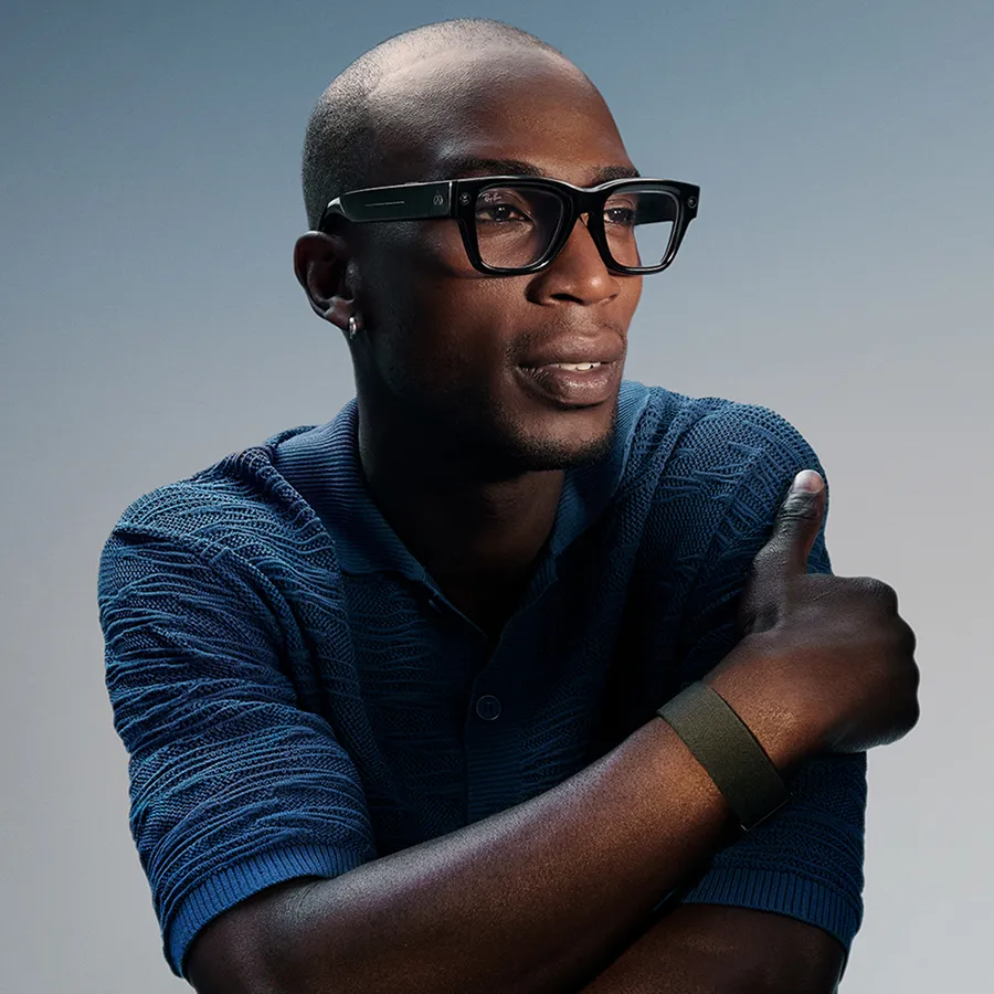 Person modeling Meta Neural Band in Black and Meta Ray-Ban Display glasses with Black frame and Grey Transitions® lens