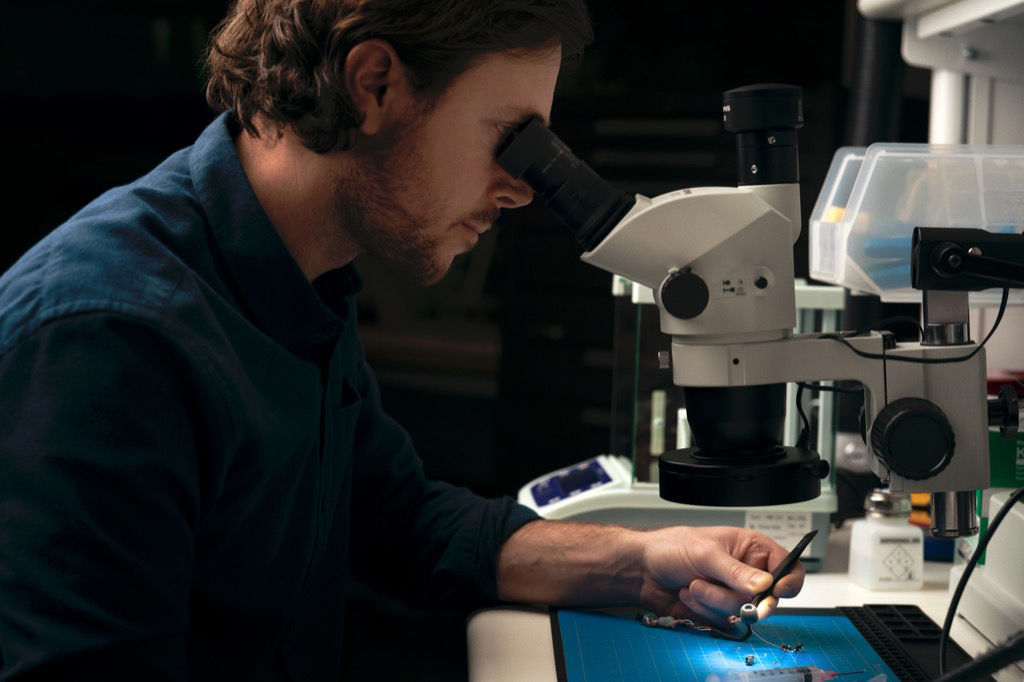 Man looking through a microscope.