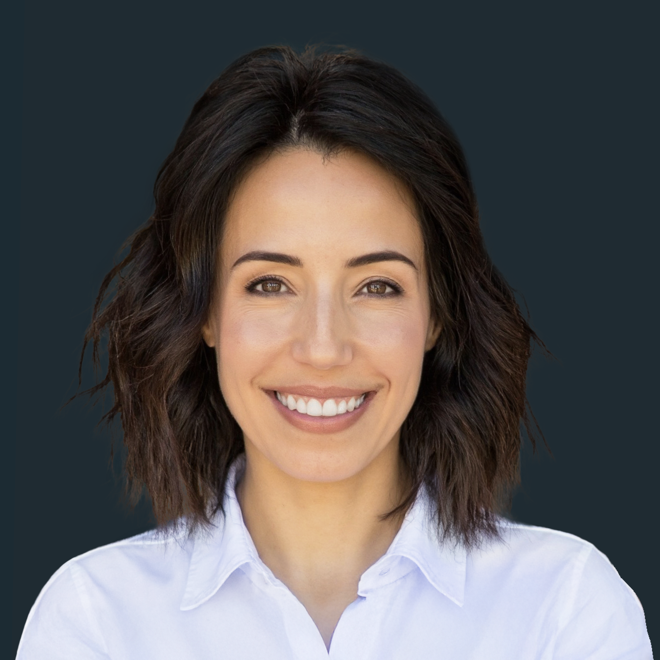 A woman with short brown hair wearing a white button-up shirt smiles against a dark background.