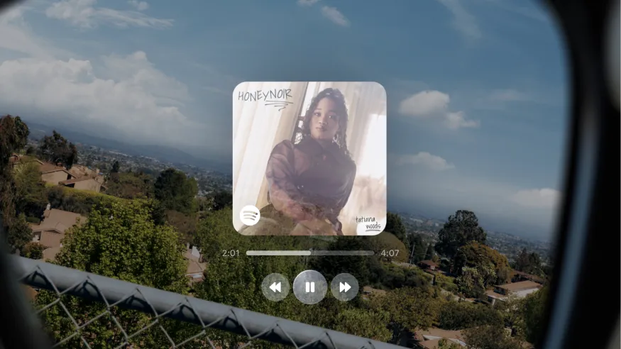 The in-lens display showing audio controls and album cover of current song.
