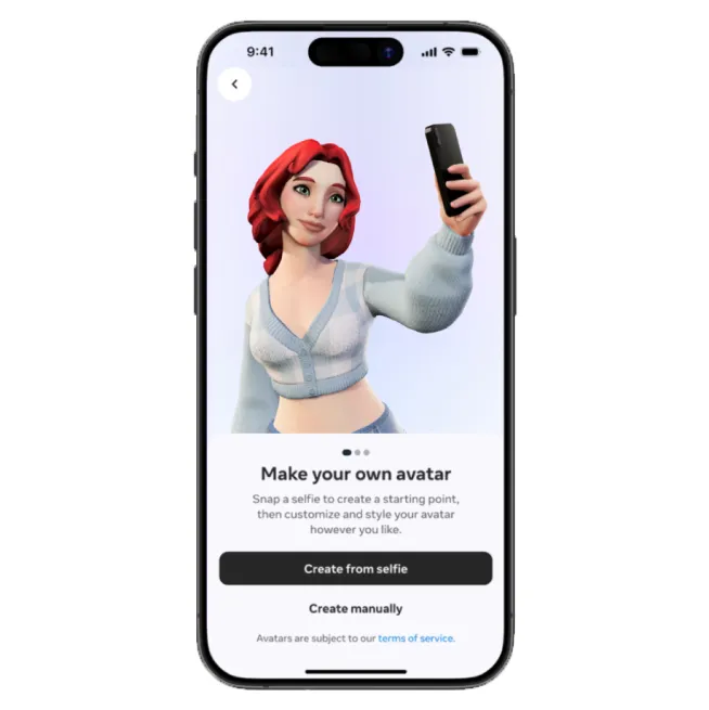 アバター作成画面が表示されているスマートフォン。赤い髪のアバターがセルフィーを取るポーズをしている。