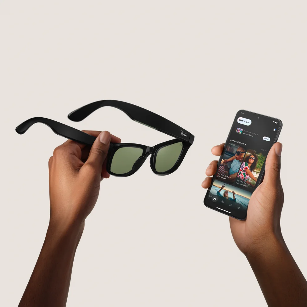 Person holding sunglasses and a smartphone with an app open