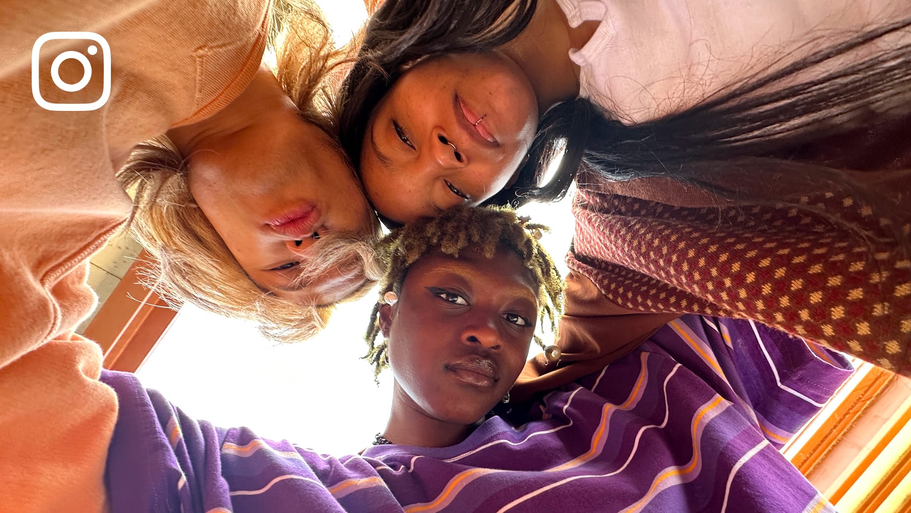 Photo shot from below, three friends huddled.