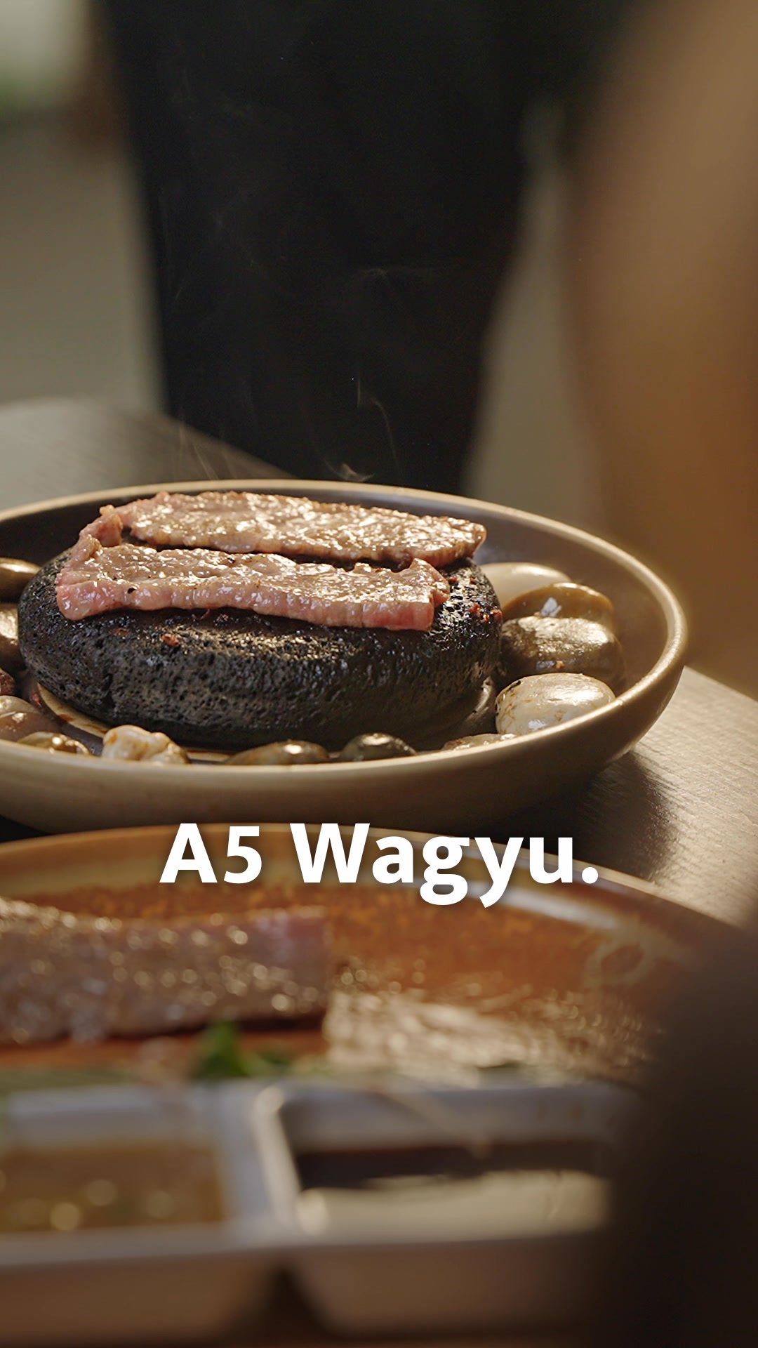 Premium A5 Wagyu, finished tableside on a scorching volcano rock