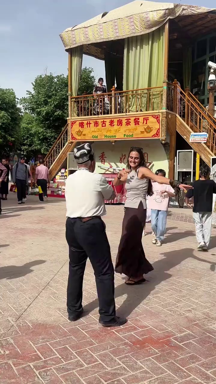 Groups of people #dance together near an old tea house in Kashgar