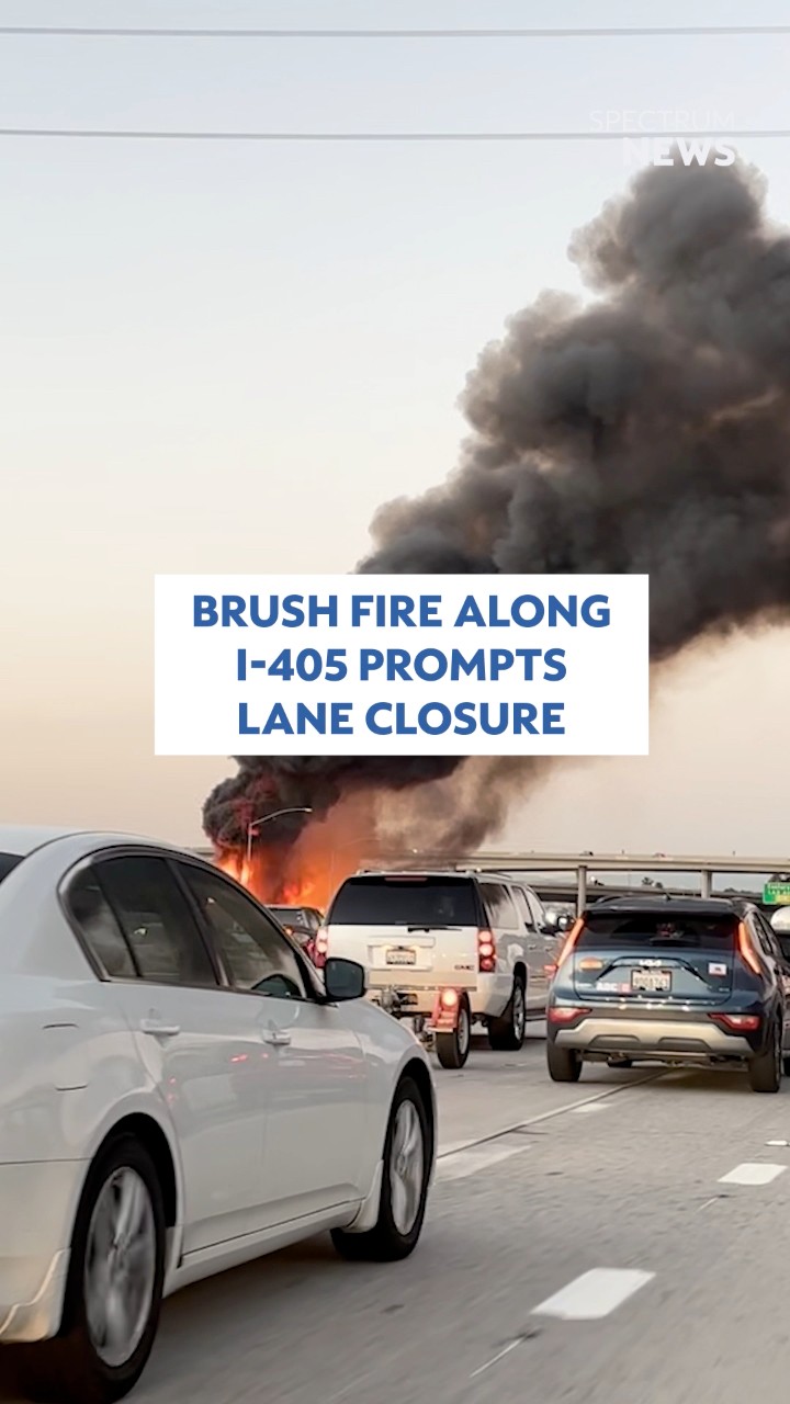 A multi-acre grass fire burning along the 405 Freeway prompted