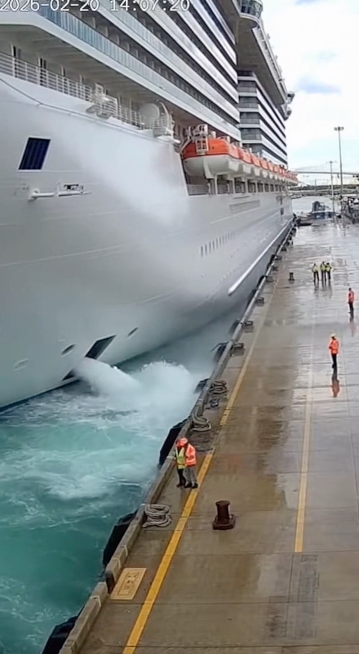 A massive cruise ship slowly edges into the dock, its towering white ...