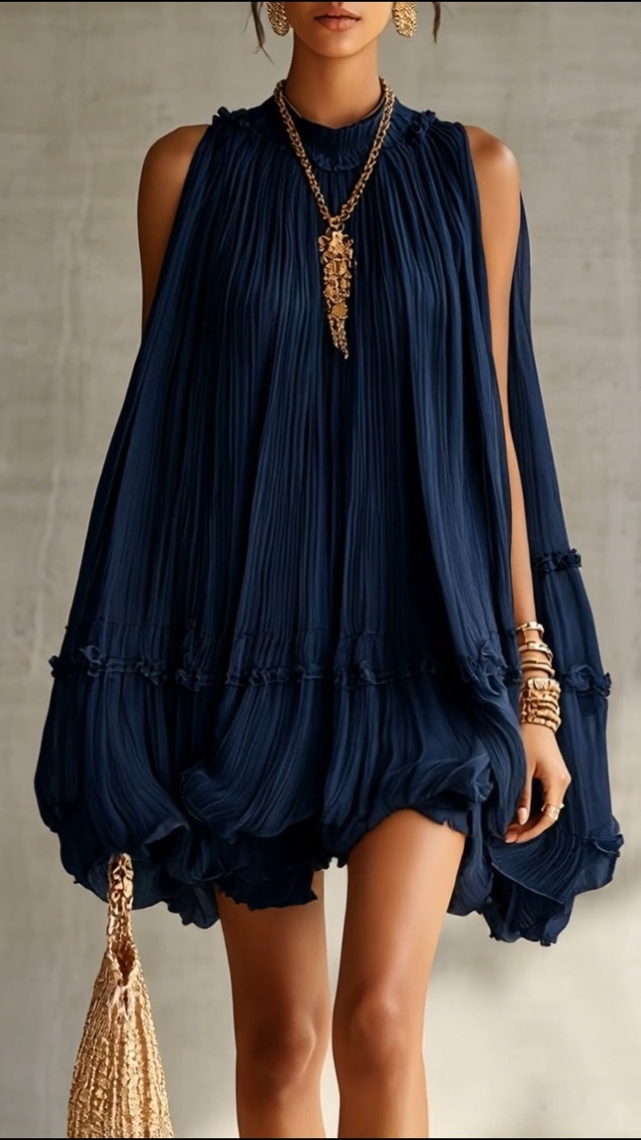 A moment for this timeless pairing: a stunning tiered navy plissé mini and opulent gold accessories. From the ruffled high neck to the gold tassel clutch, it's all in the details. Perfect for an 