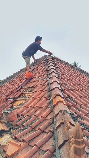 Installing the ridge angle of the roof of a wooden stilt house with the ...