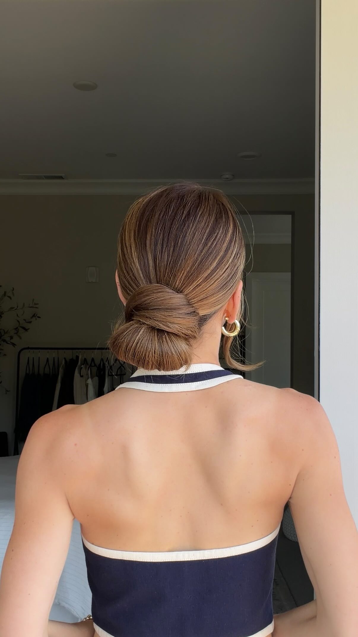 The low bun you need to try! 💁‍♀️, Gather your hair into a low ponytail. Start wrapping your hair elastic around the ponytail, but stop when you create a small loop. Stretch the elastic with one hand