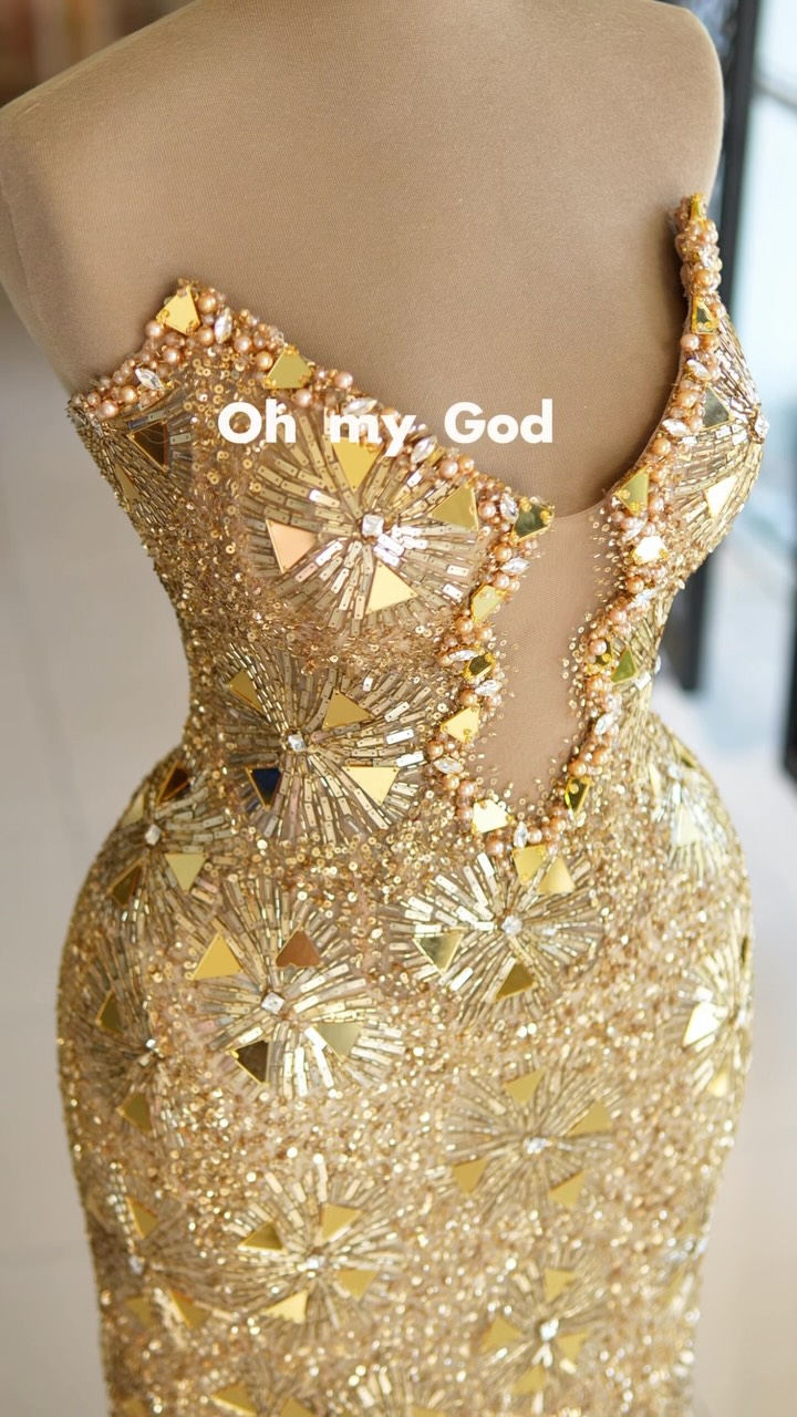 Luxury gold evening gown with crystal embellishments., Every detail is designed to shine. Featuring a sculpted illusion corset, hand-placed crystals, mirror embellishments, a sleek fitted silhouette, 