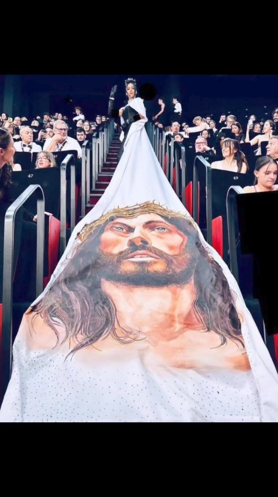A woman walks the Cannes Film Festival red carpet in a dress depicting Jesus in a move many are calling blasphemous: 