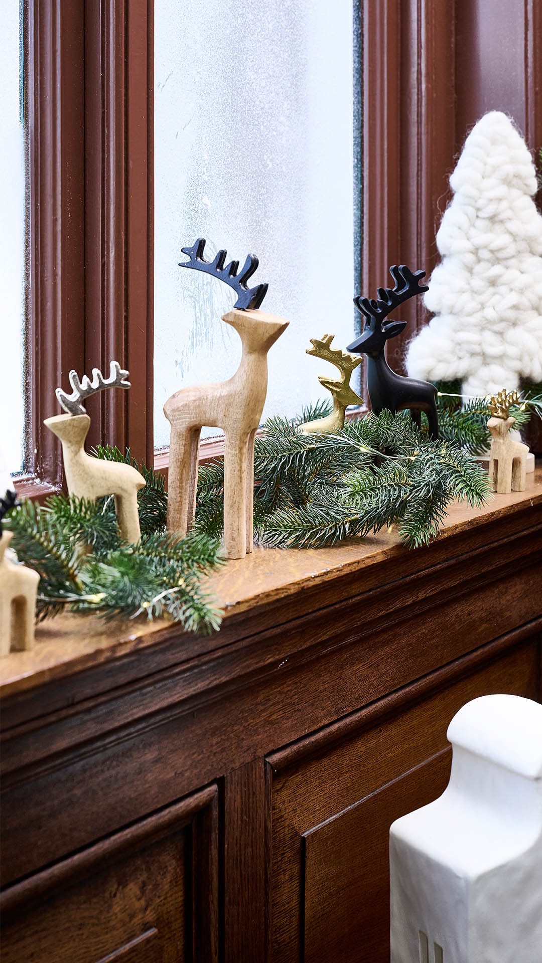Eine hübsch dekorierte Fensterbank im winterlichen Stil läutet die kommende Saison ein. Die grüne Tannengirlande bildet die Basis auf der Hirsche und Tannenbäume ihren Platz finden.❄️🎄🦌, So lässt es