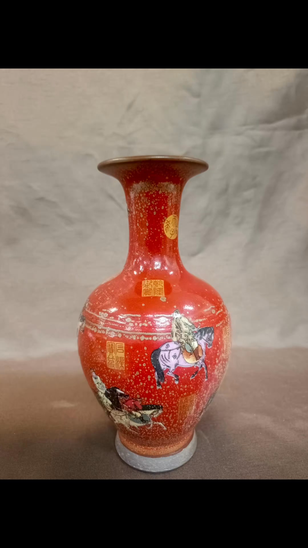 清光绪珊瑚釉粉彩描金人物瓶。 图片展示的是一个红色的花瓶，其特点和