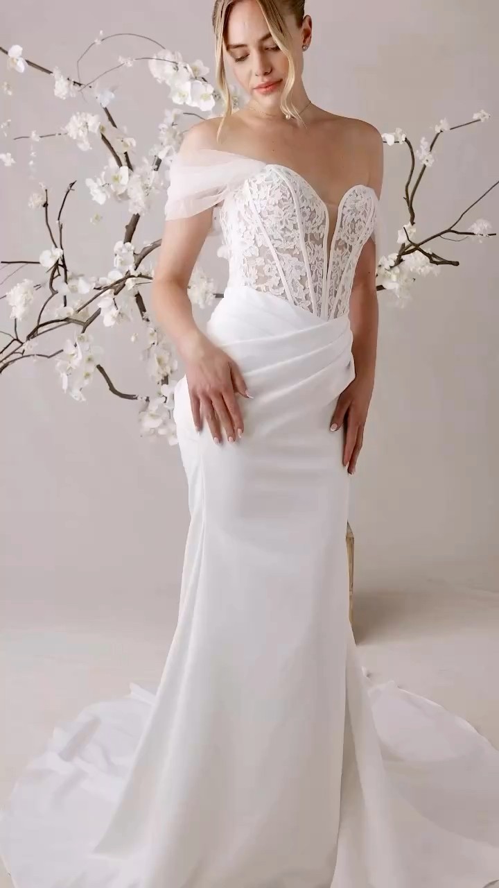 Just arrived at Saint Bridal!! Meet Plies! 🤩, Fit and flare wedding dress has a sheer, lace embroidered bodice with a plunging strapless sweetheart neckline and corset boning on a wrap-style crepe 