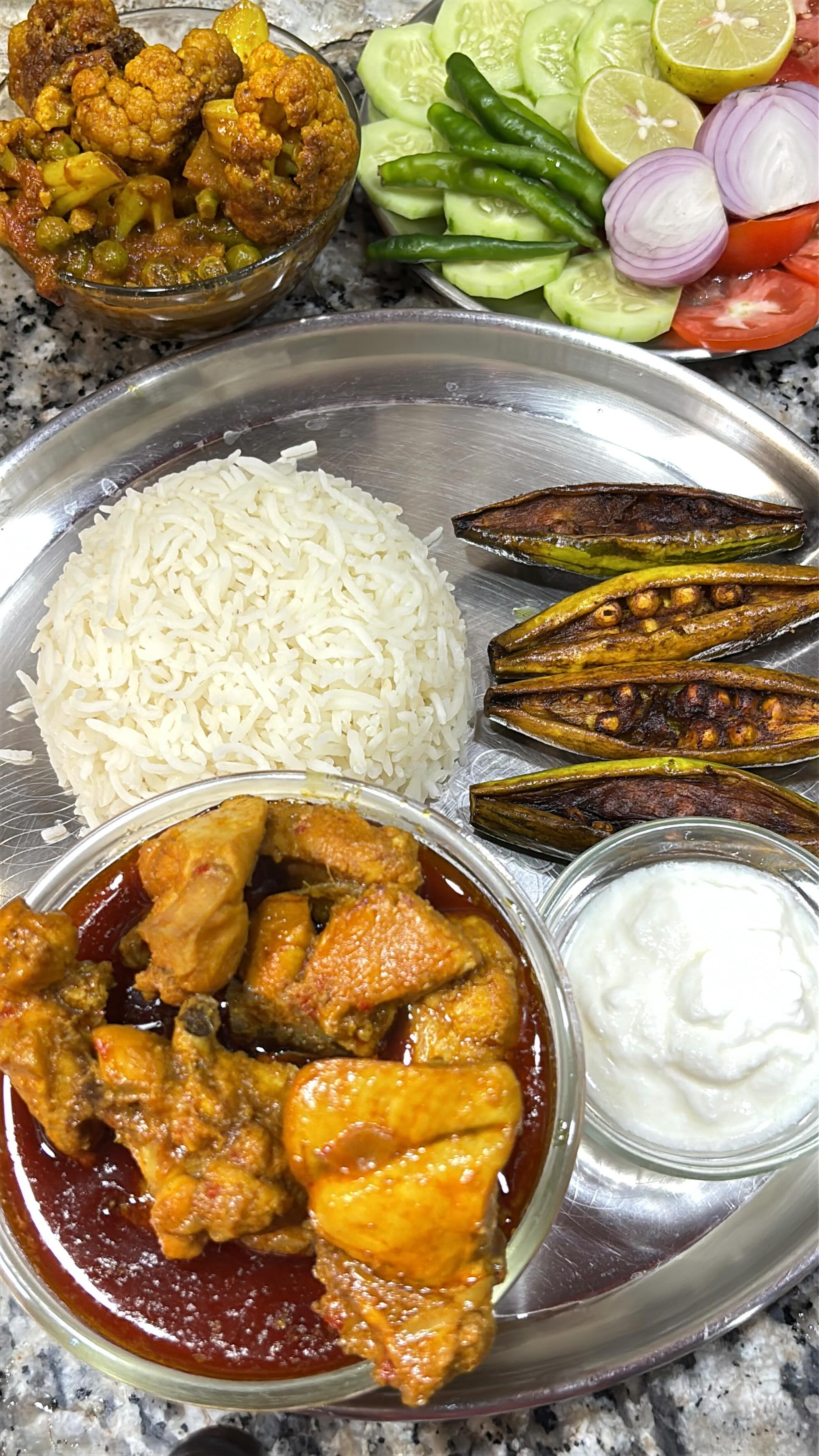 Traditional Bengali thali with chicken kosha and rosogolla