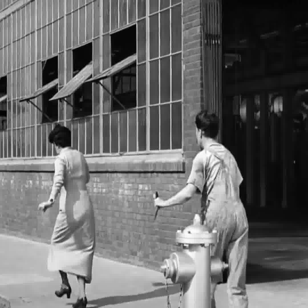 Charlie Chaplin posing as a factory worker holding his wrench for