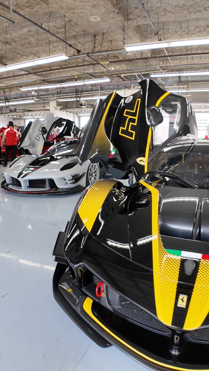 A group of Ferrari FXX-K Evos waits in the paddock before heading