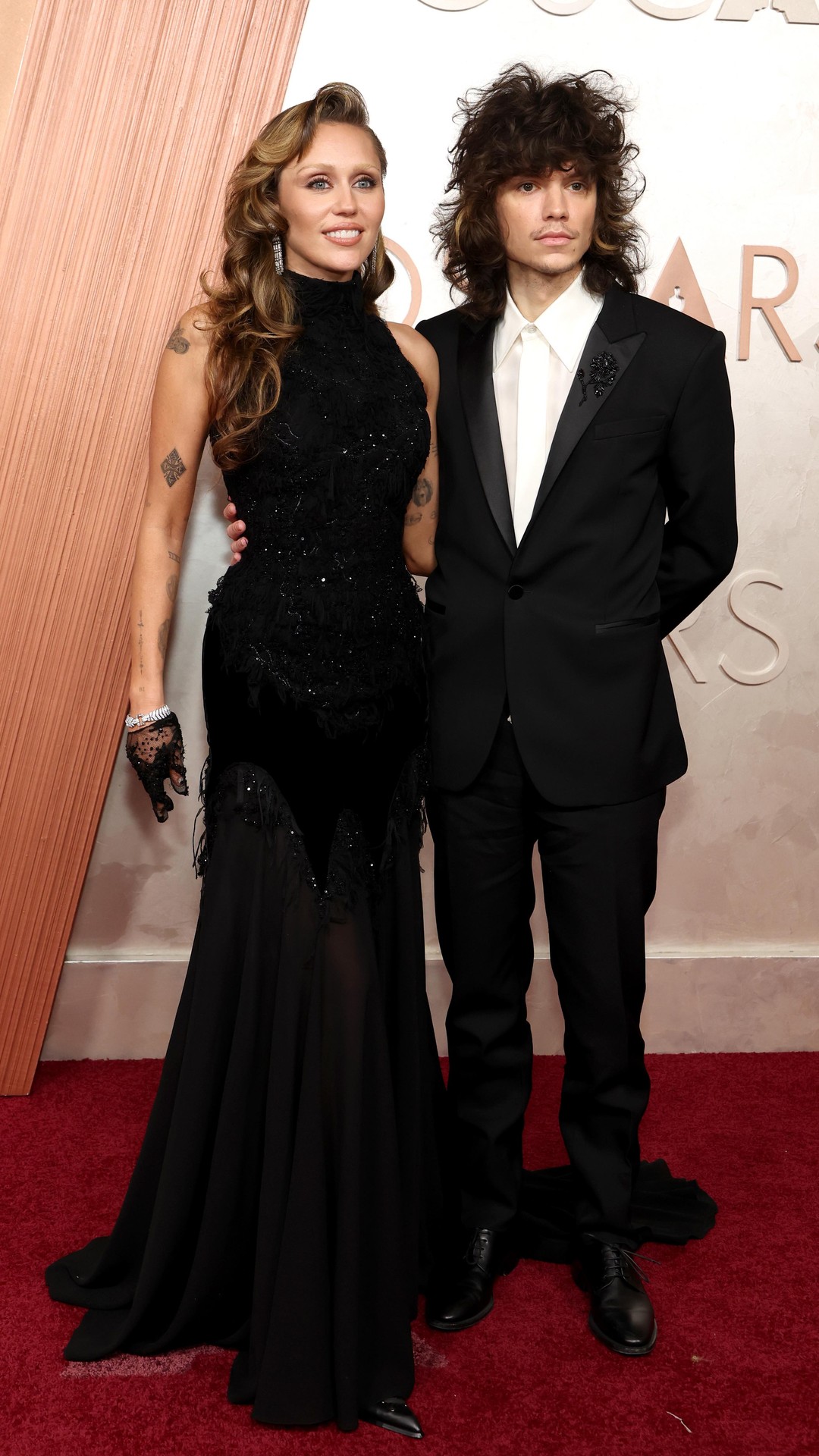 #MileyCyrus and #MaxxMorando are matching in black on the #Oscars red ...