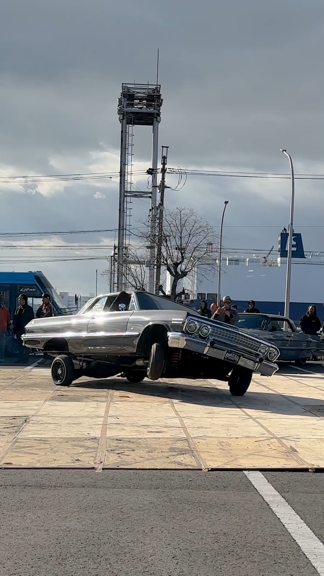 A pair of Chevrolet Impala LOWRIDERS tipping in 3 wheel motion during ...