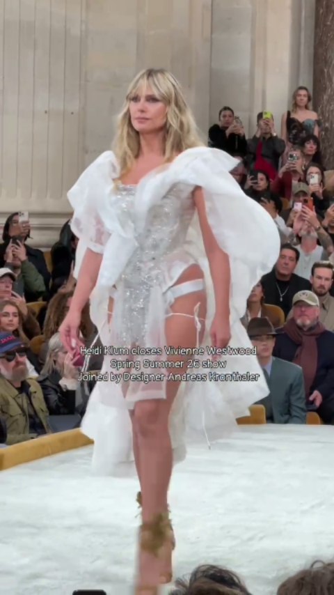 At Vivienne Westwood's SS26 runway, Heidi Klum embodied bohemian glamour in an extravagant bridal look complete with a shimmering corset. For the finale, Designer Andreas Kronthaler joined Heidi to close the show