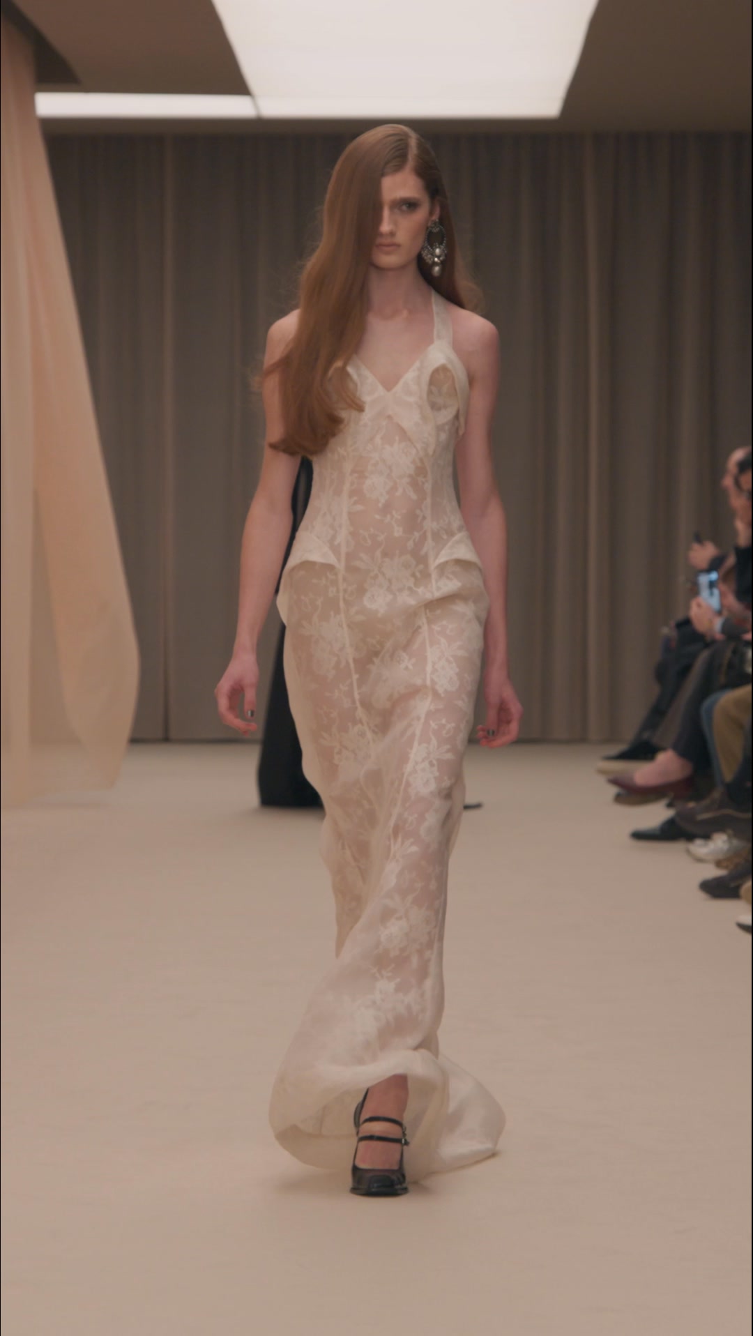 McQueen Autumn Winter 2026 – Yura in look 36. , A sculpted dress in white floral lace trapped in shell pink organza. Niko Mary Jane pumps in black leather. | Alexander McQueen
