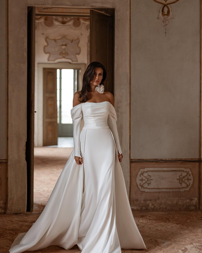 Our 'Kamilla' gown is classic with modern touches in soft satin ❤️ Optional detachable train Further information and prices on our website #bardotneckline #longsleeveweddingdress #nibride #2025bridetobe #modernbridal #lisburnbridalboutique