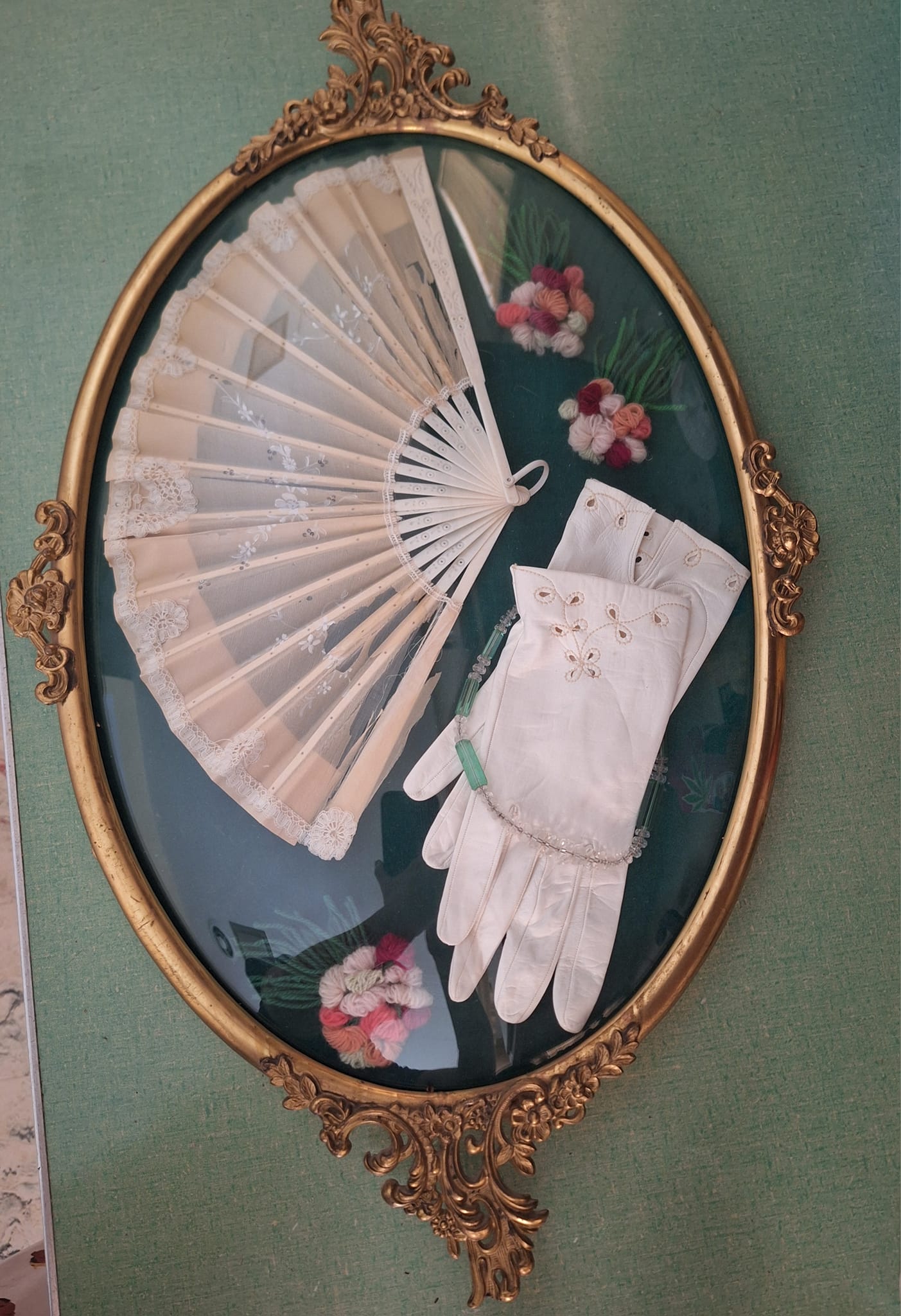 What is the origin and meaning of this antique fan and gloves in a