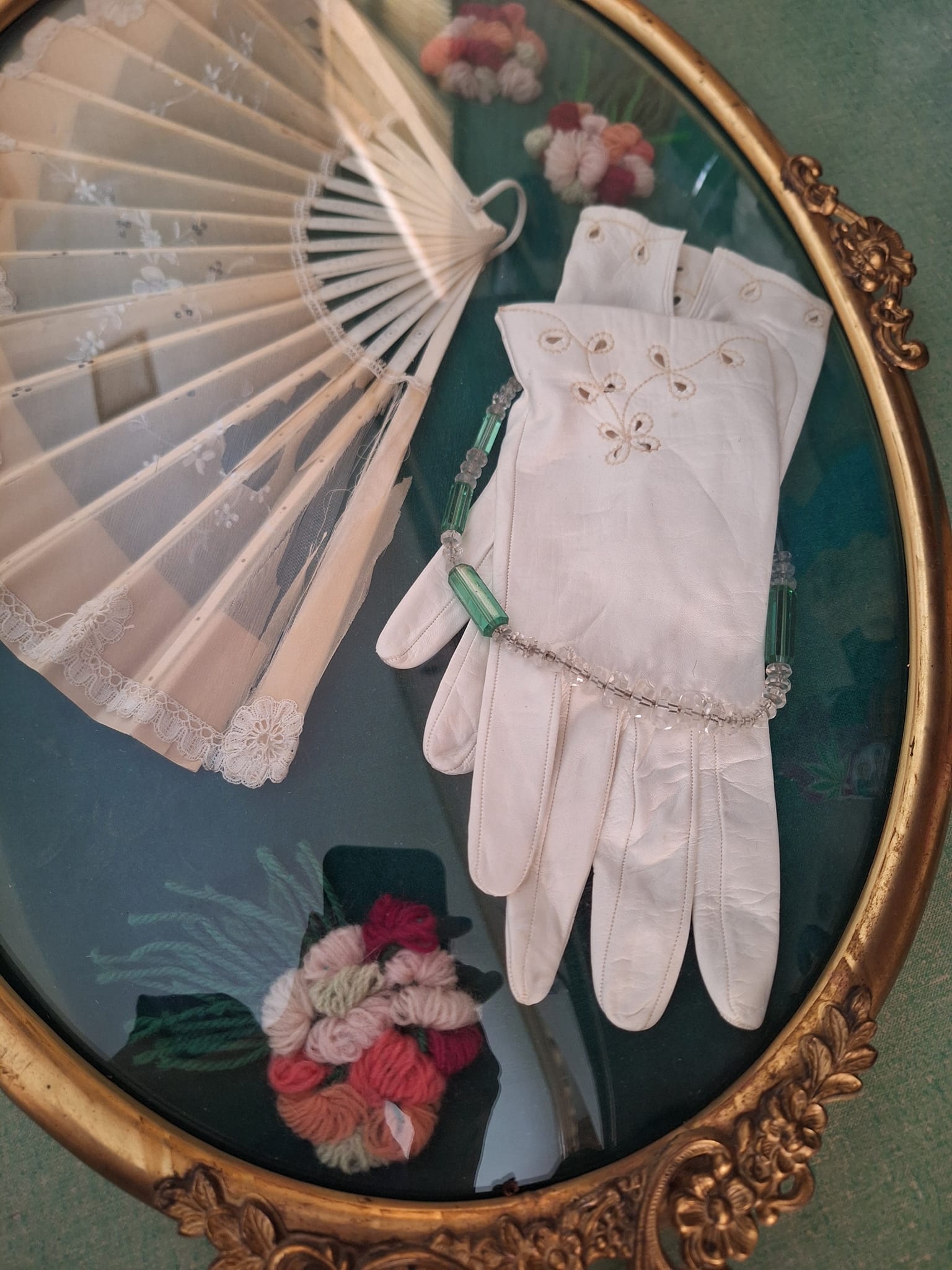 What is the origin and meaning of this antique fan and gloves in a