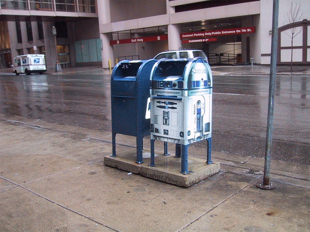 People walk by a US Postal Service mailbox designed to look like 