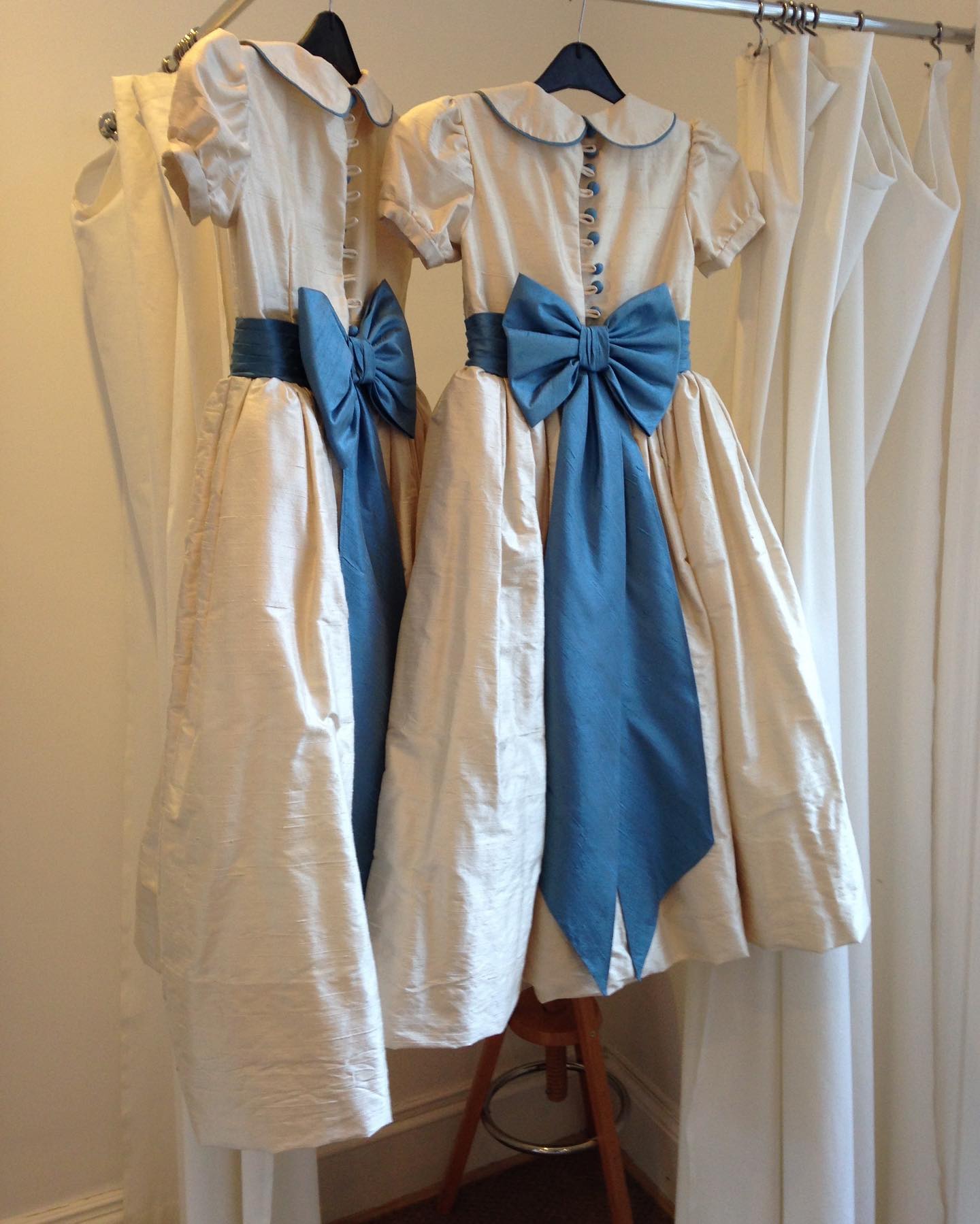 white dress with blue satin sash Elegant ivory flower girl dresses. Each sleeveless gown has a round neckline and a pleated A-line skirt. The waist is detailed an embroidered lace band and a central bow Color:Marigold