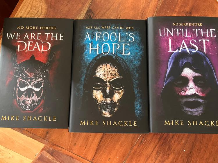 Photo is a collage of the covers of the three books in the Last