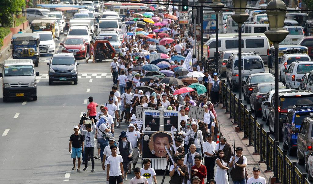 Philstar.com - Protesters march with a mock train with a picture of ...