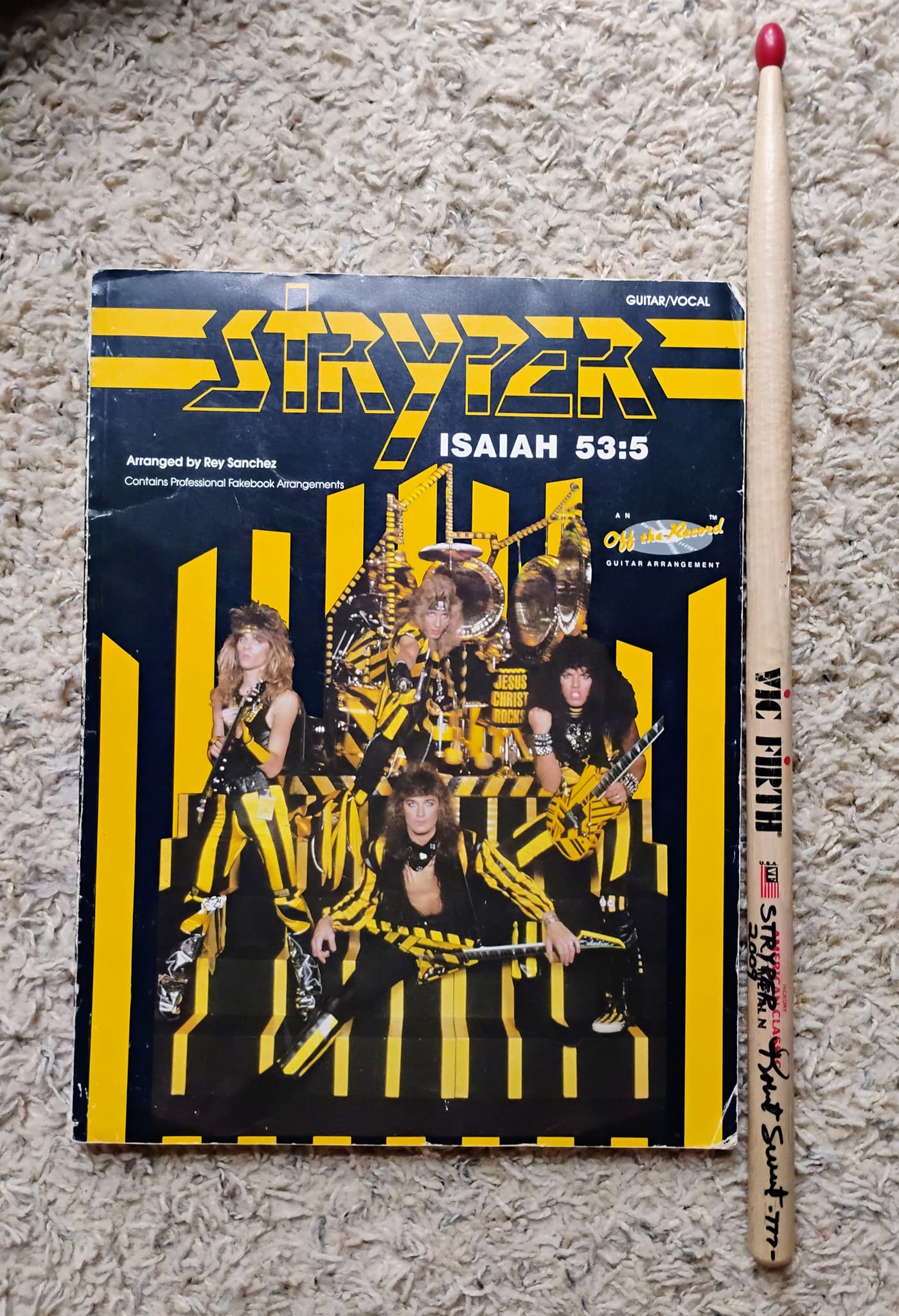 Stryper guitar tab book, and drumstick signed by Robert Sweet