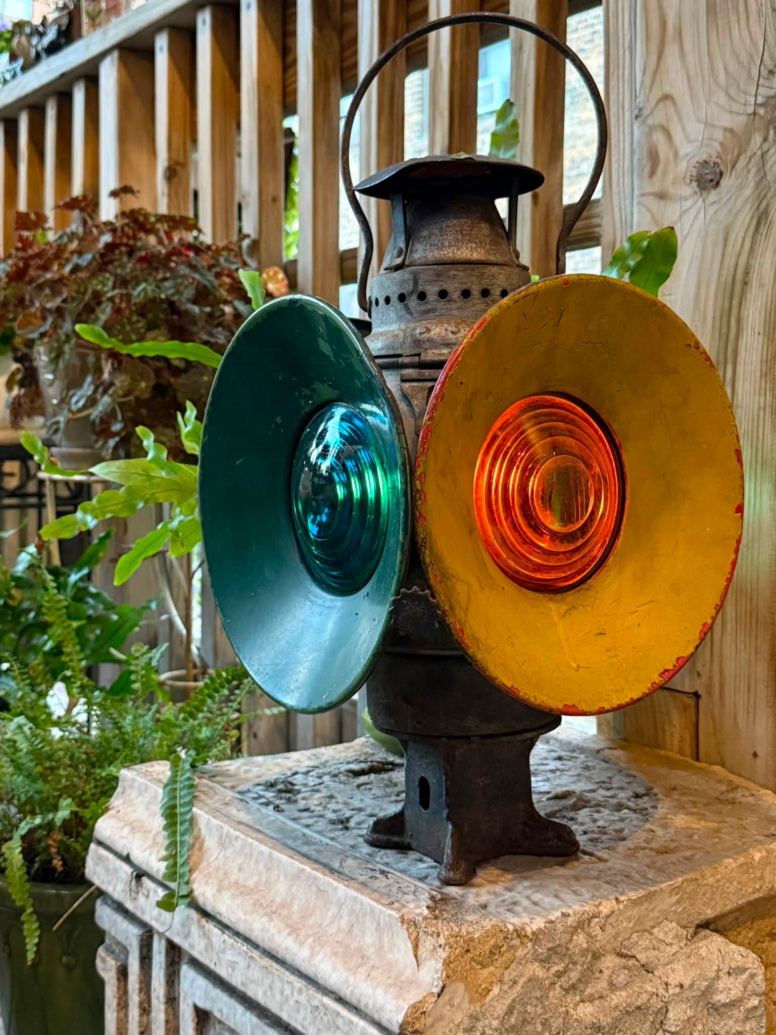 Restored Adams & Westlake railroad switch lamps in a deck garden