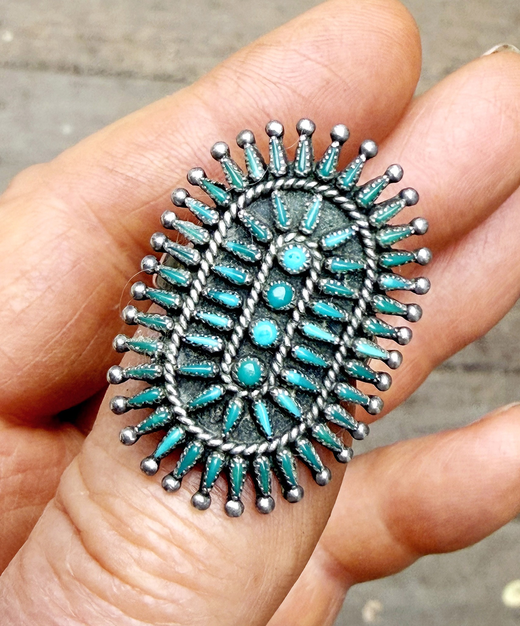 Whose signature is on this Zuni needlepoint jewelry?