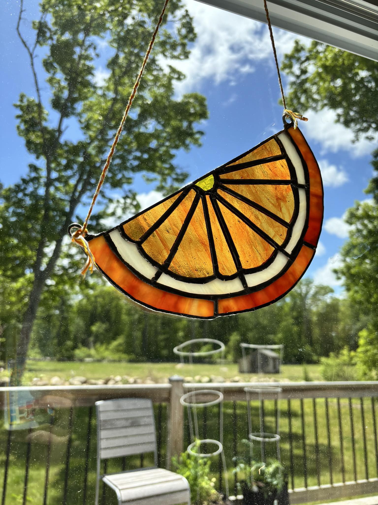 Stained glass orange slice suncatcher with sunlight