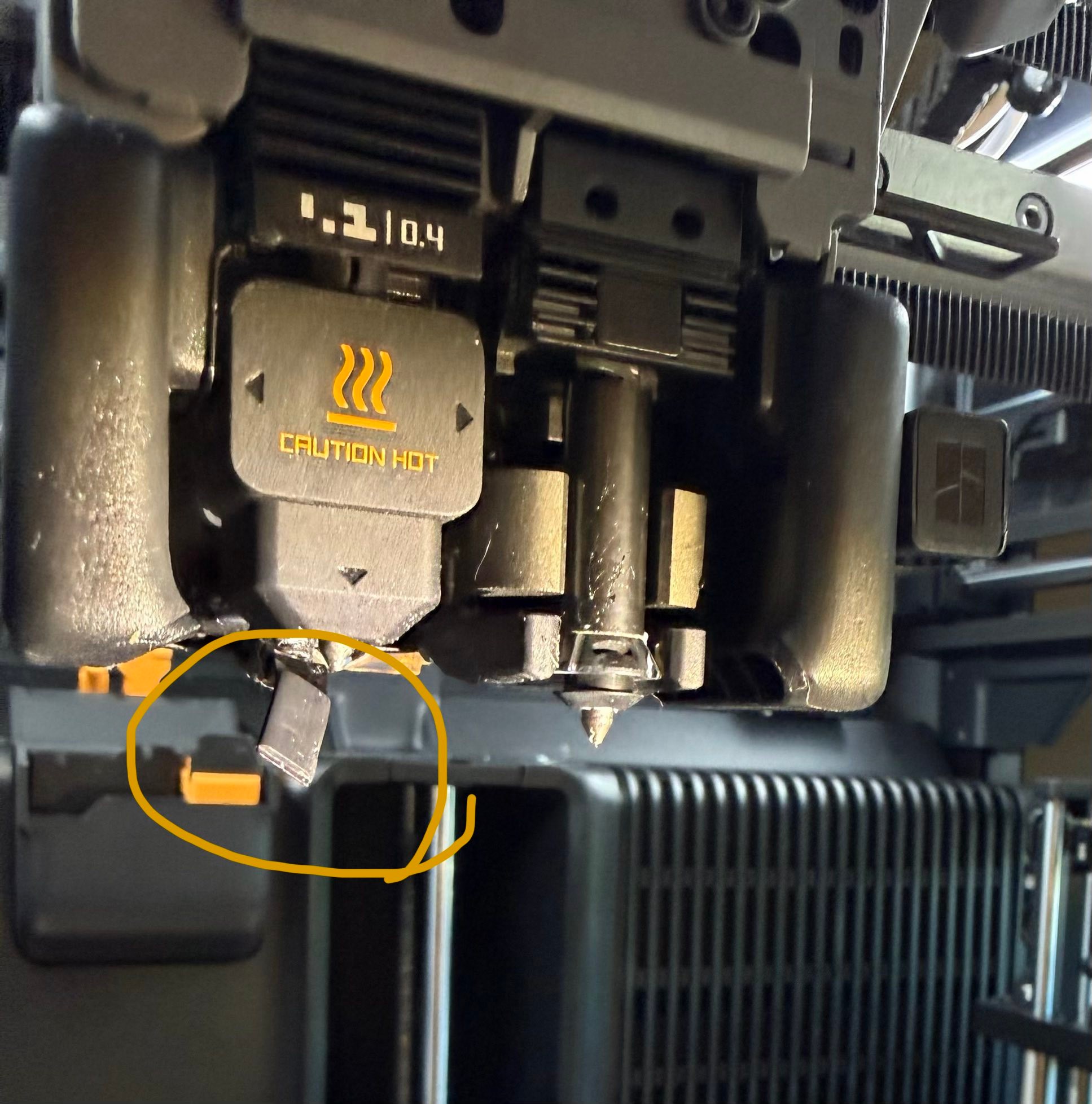 What is the black tab under Bambu Lab H2C left nozzle?