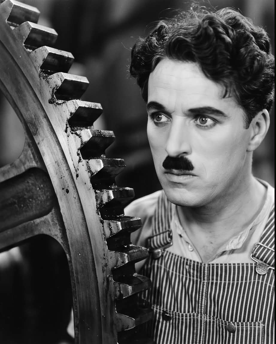 Charlie Chaplin posing as a factory worker holding his wrench for