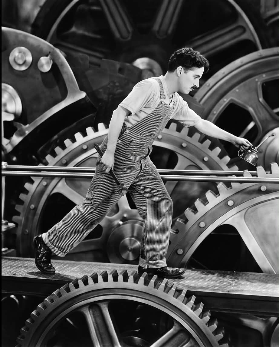 Charlie Chaplin posing as a factory worker holding his wrench for