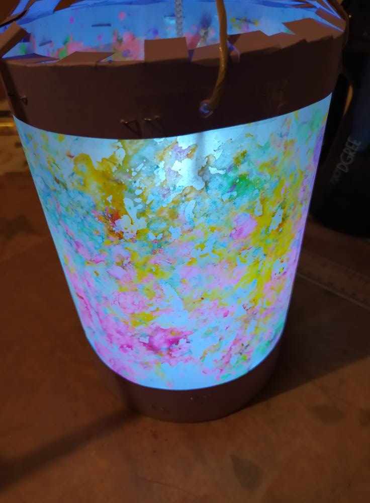 Unsere Laterne ist dieses Jahr aus geschmolzenen Wachsmalstiften. Backpapier drunter, mit Wachsmalstiften anmalen oder sie draufraspeln. Man kann sie auch schon vorher raspeln und die gleichen Farben in schälchen sammeln und das