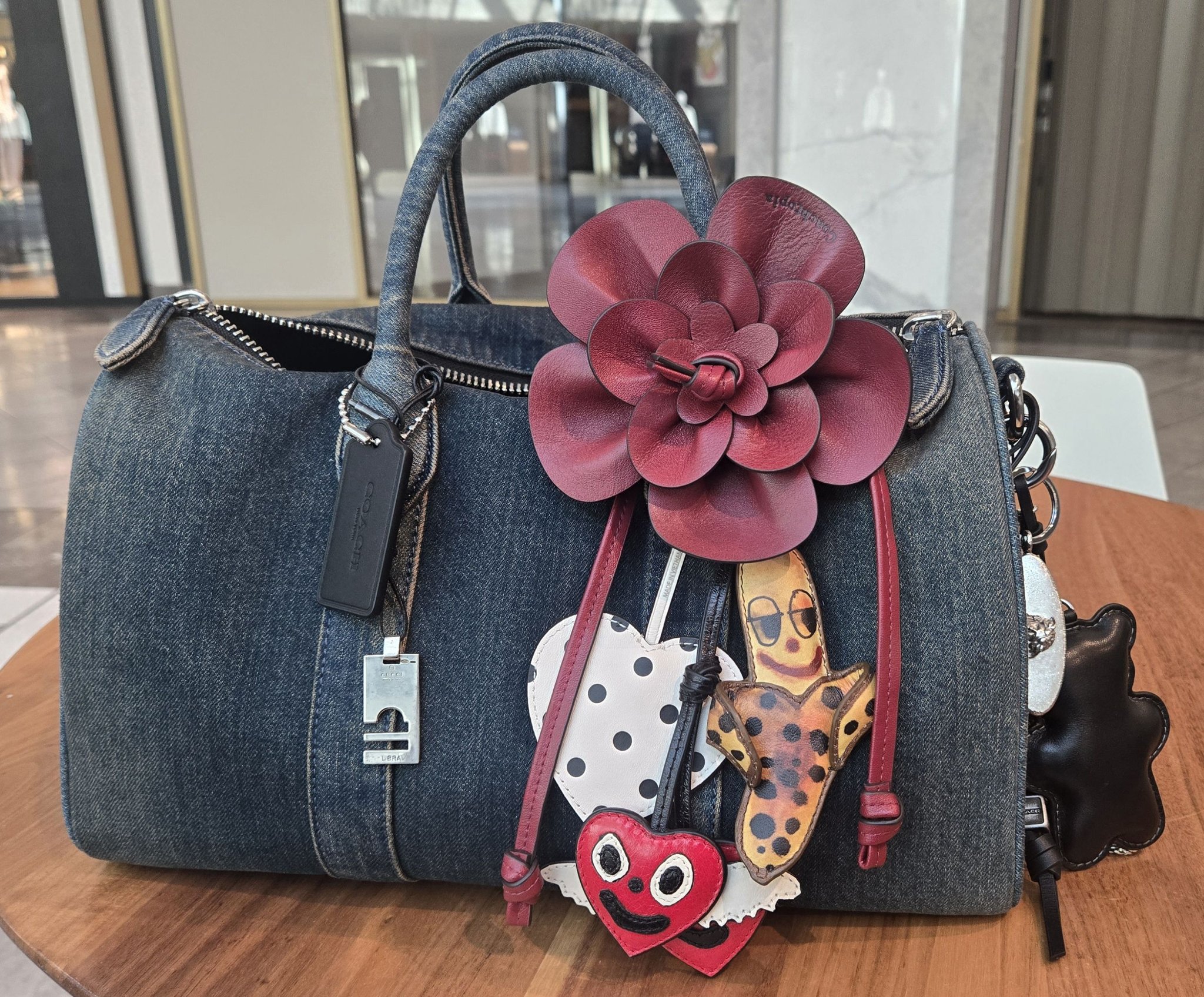 Coach bag with various charms and accessories