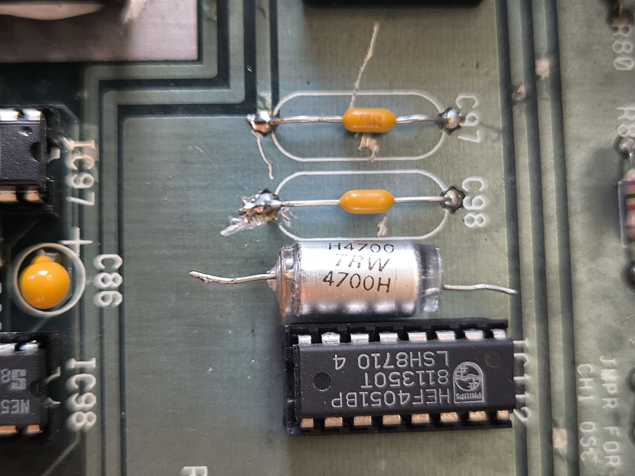 The image shows two large blue electrolytic capacitors, commonly