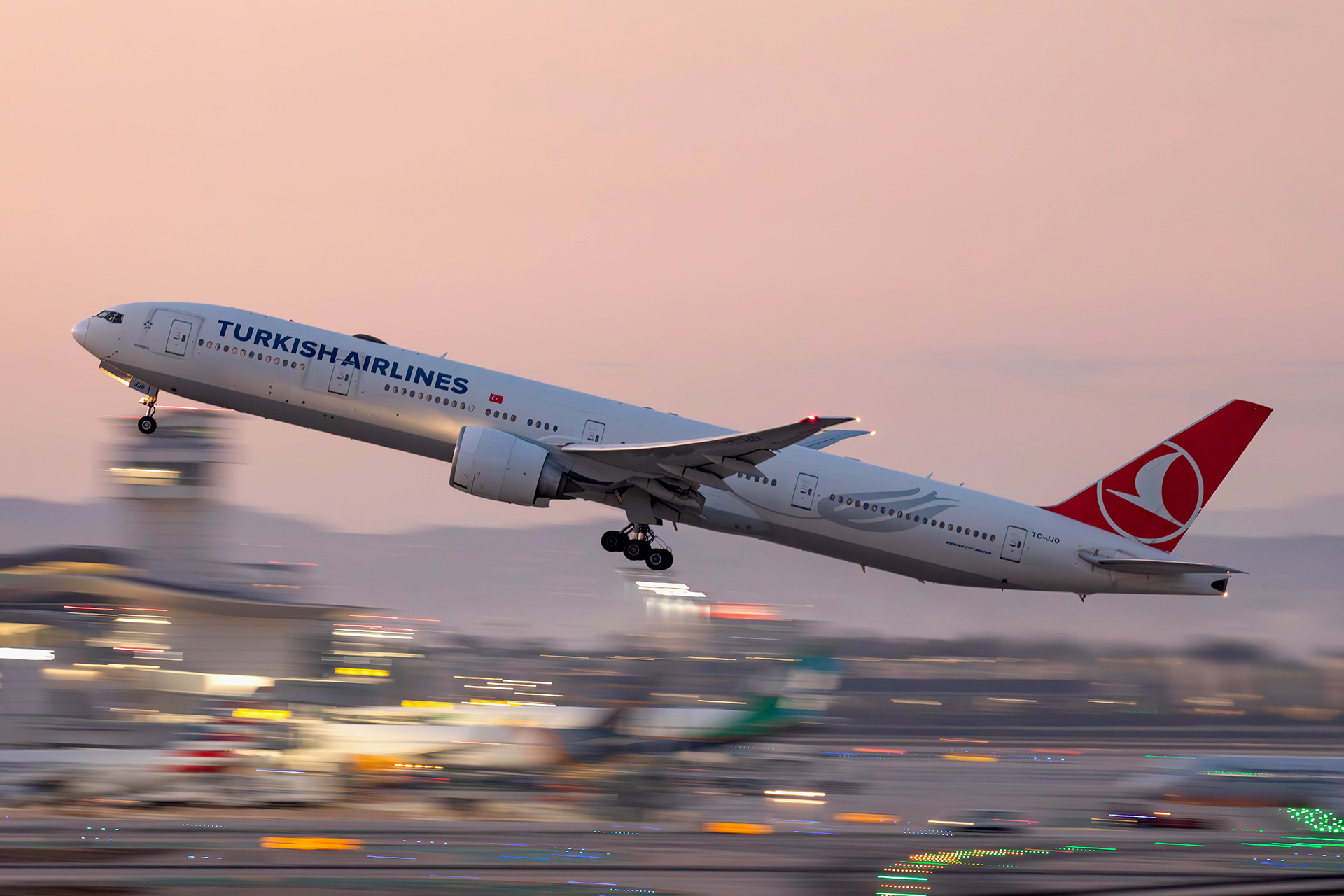 A Turkish Airlines Boeing 777-300ER climbs out of Runway 25R at