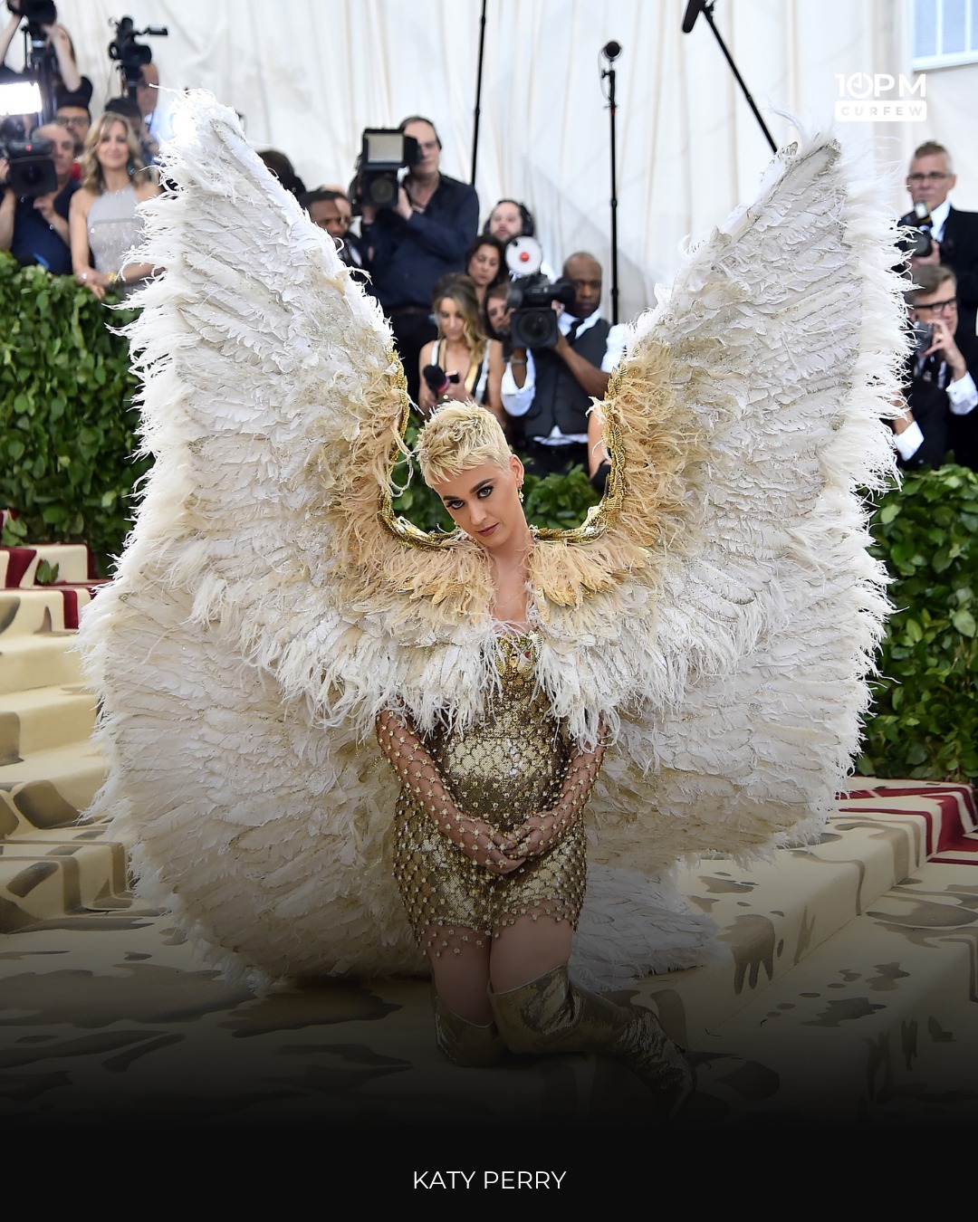 katy perry coronation gold dress stole the show in a heavenly Versace mini paired with enormous feathered angel wings, making a bold and unforgettable entrance Scoopneck