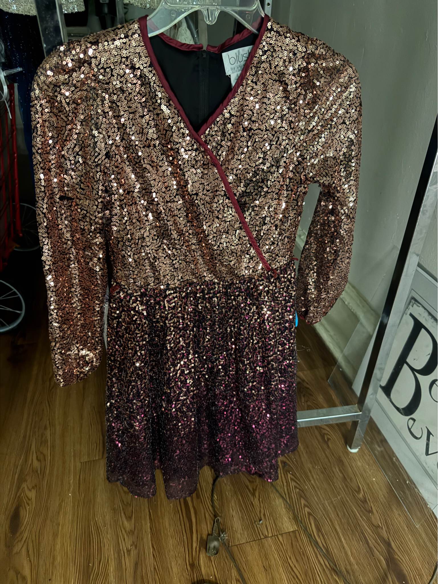 Sparkling sequin wrap dress in a rose gold to burgundy ombre. This size 14 garment from Blush by Us has long sleeves, a V-neckline, and a back zipper closure