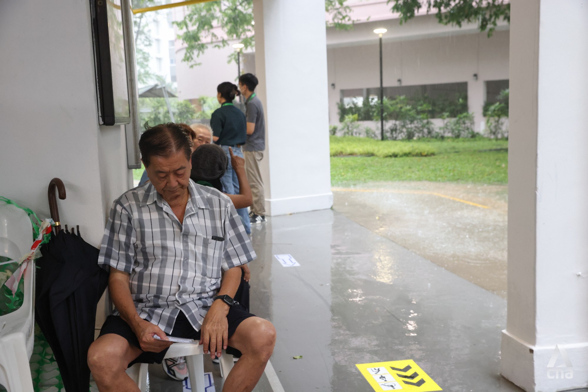 CNA - Queues form amid a heavy downpour at the polling station at Block ...