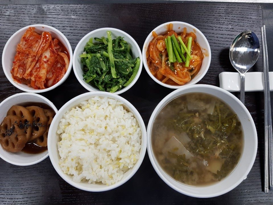 삼인요양병원 - 2월13일 중식 식단입니다. 기장밥, 냉이된장국, 해물콩나물찜, 연근조림, 열무나물, 배추김치.