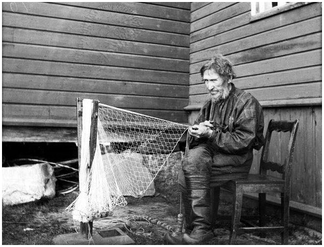 black and white sailor with a net full of fish Browse Free HD Images People Pulling Fishing To Shore In Fishermen mending fishing nets Stock